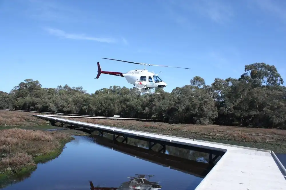 Helicopter flying low over wetlands as part of a mosquito management program.